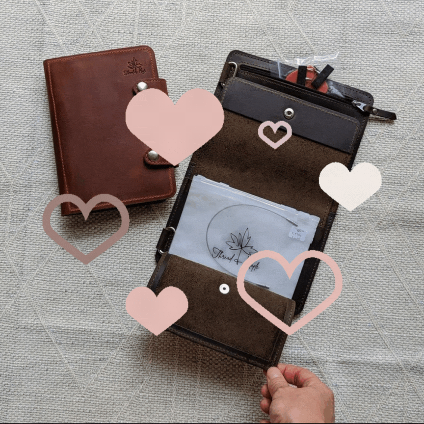 Brown leather planner with heart design, open to show interior compartments and paper inserts.