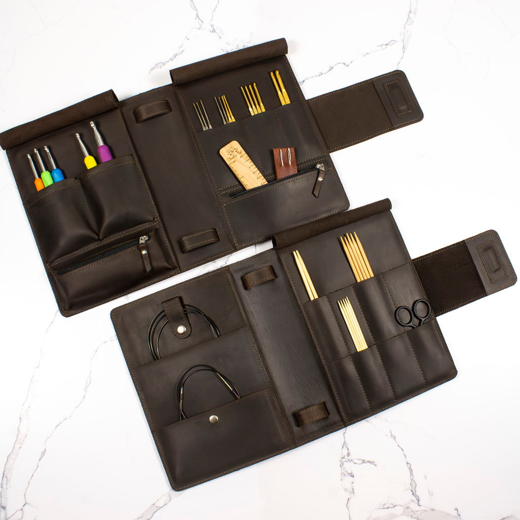 Elegant black leather organizer showcasing various compartments for tools and accessories on a marble surface.