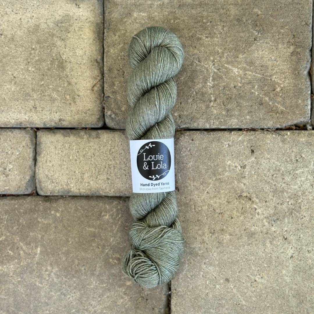 Skeins of green yarn on stone tile background