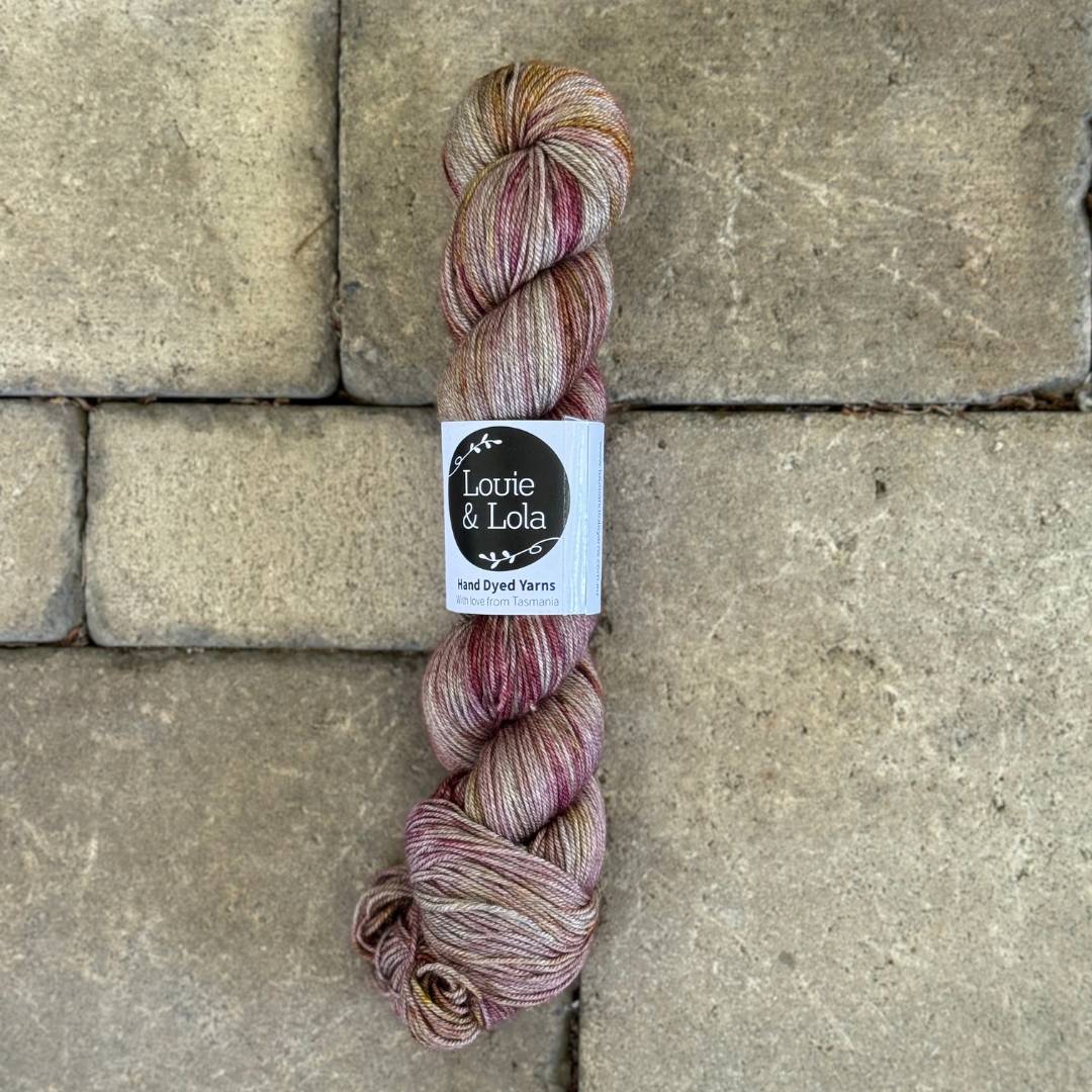 Multicolored yarn skein with label on stone tile surface