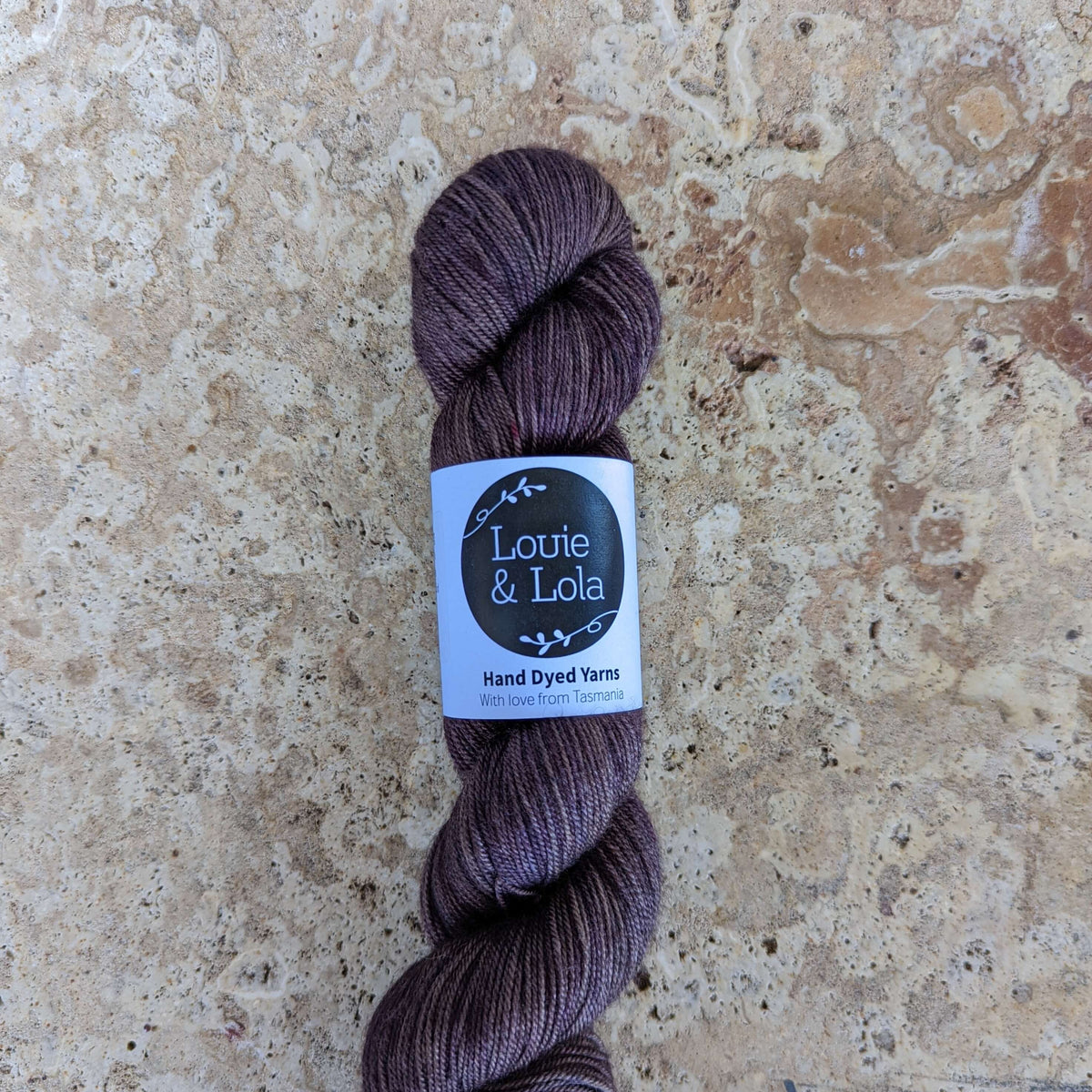 Skein of brown yarn on a textured stone background