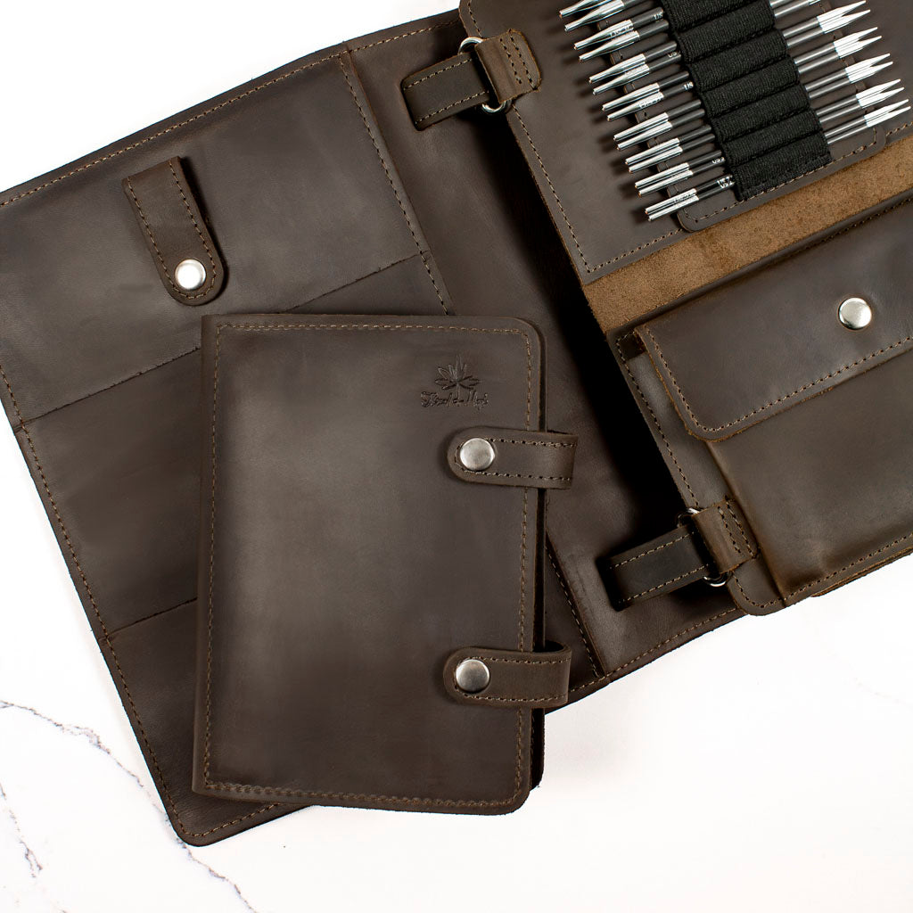 Open brown leather portfolio featuring pen slots and document compartments on a white background.