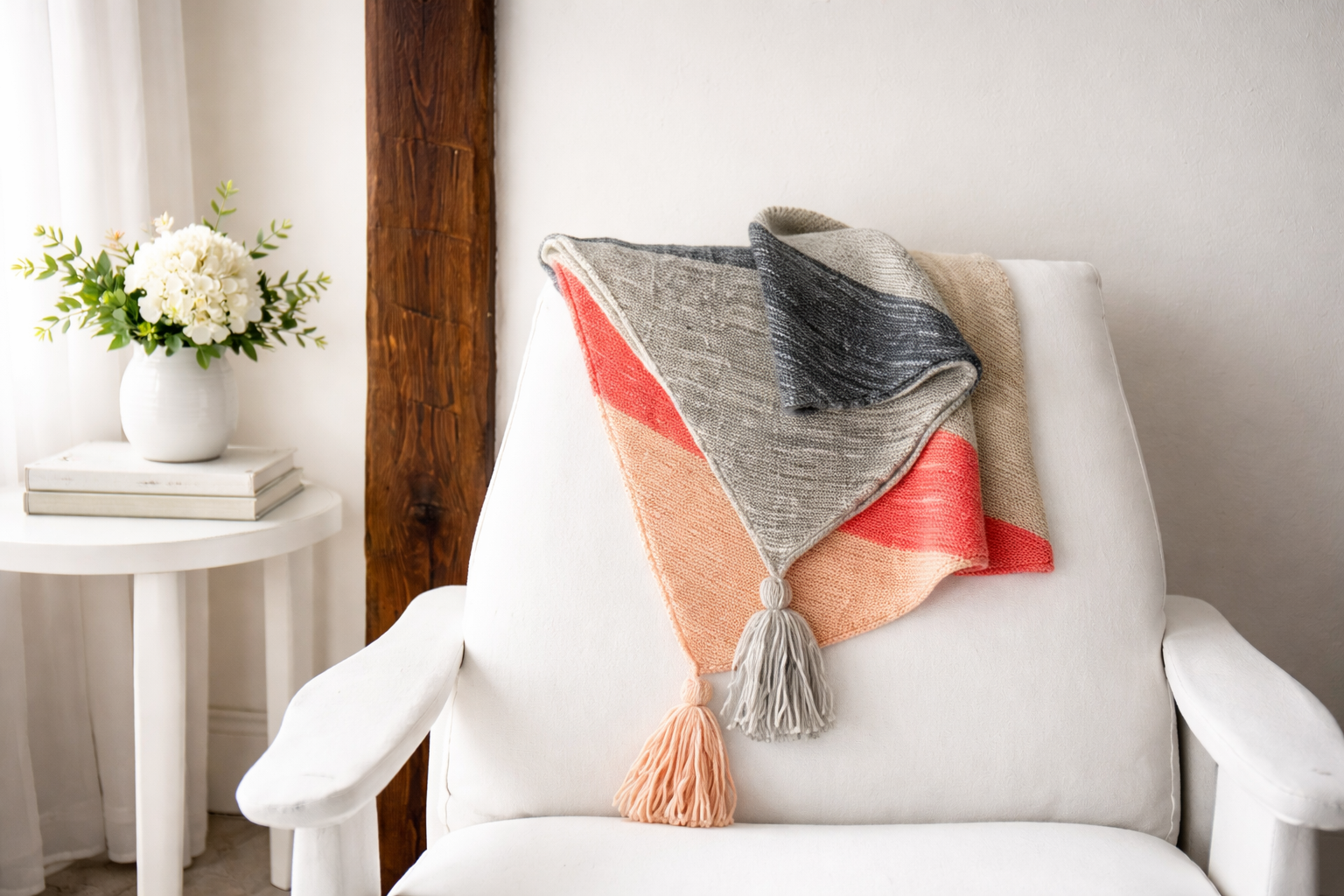 Folded striped throw blanket with tassels.
