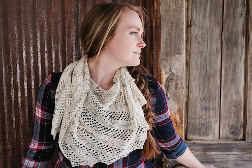 Woman wearing cream lace knit shawl.