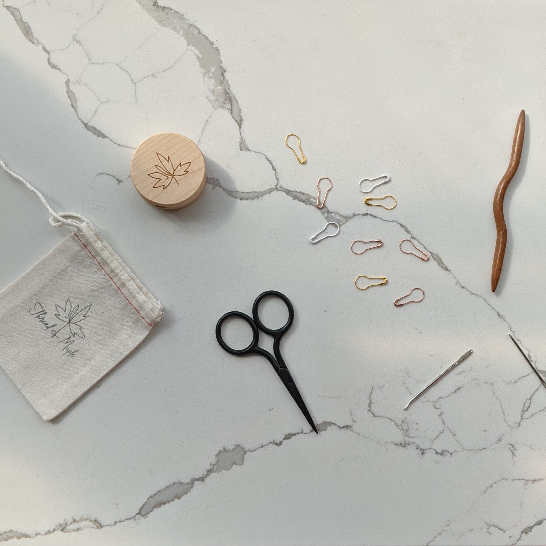 embroidery scissors stitch markers tape measure cable needle